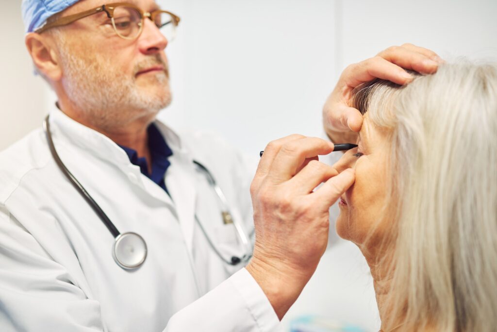 Doctor drawing with marker on adult patient face