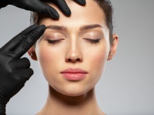 Face skin check before plastic surgery. Beautician touching woman face.