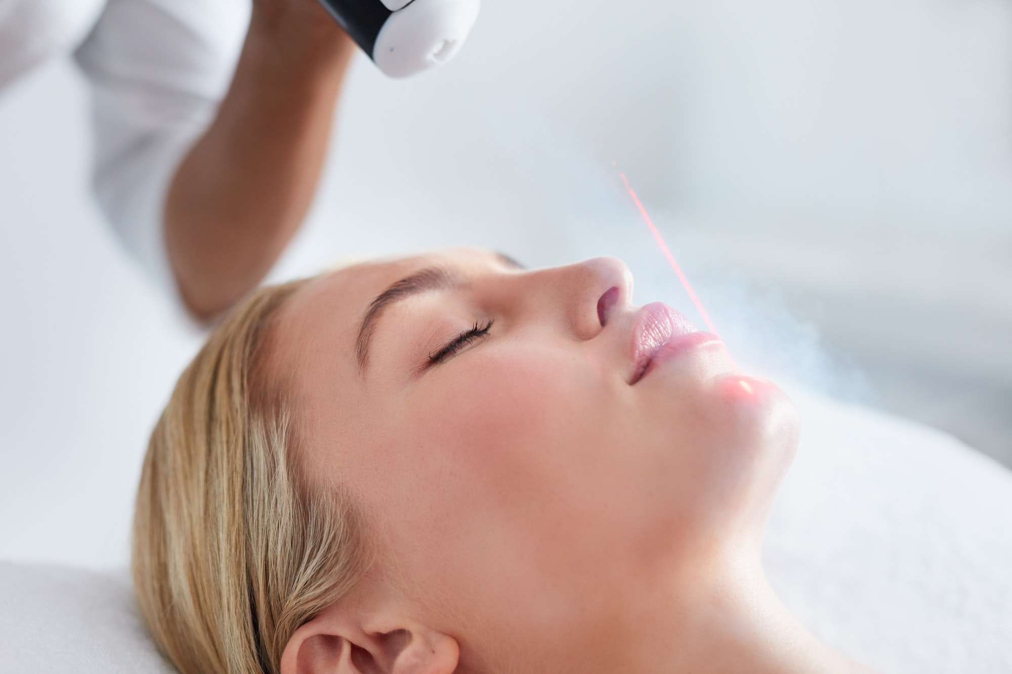 Young woman receiving local cryotherapy on her face
